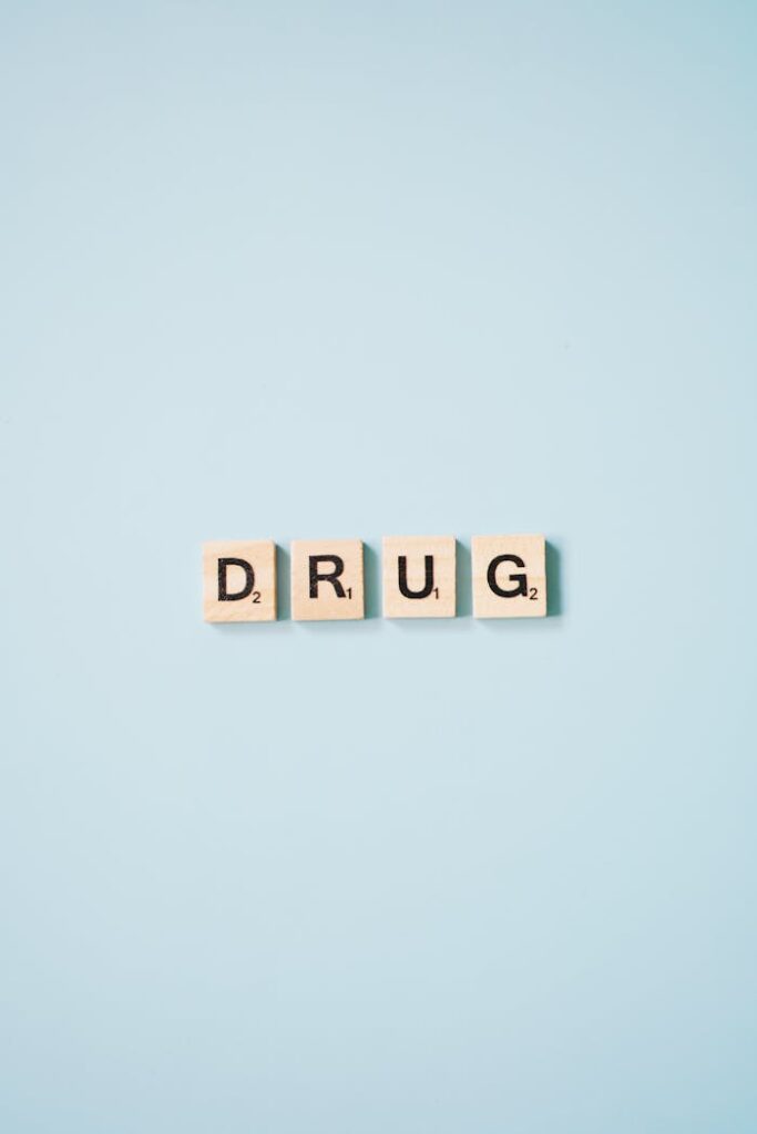 Scrabble tiles arranged to spell 'DRUG' on a light blue background.
